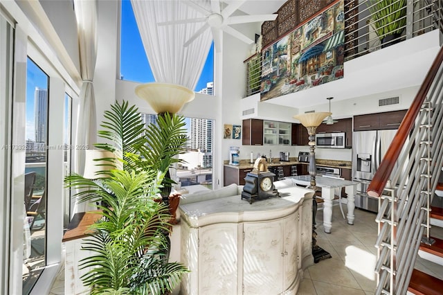 tiled living room with sink and a towering ceiling