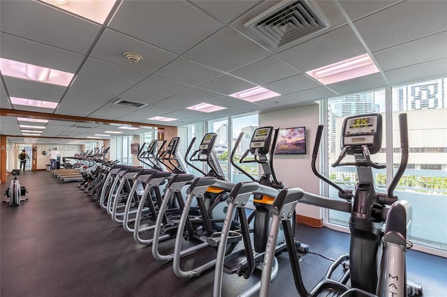 workout area with a paneled ceiling and plenty of natural light