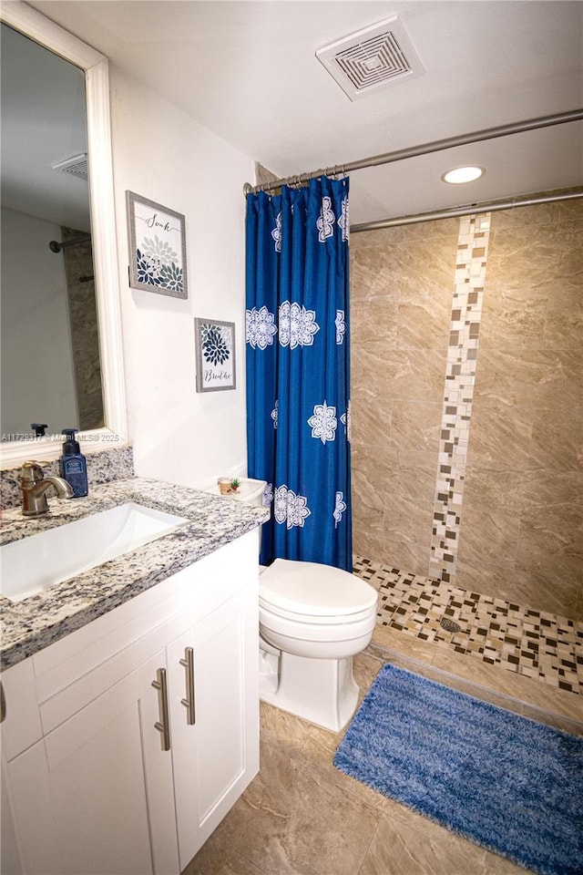 bathroom featuring vanity, curtained shower, and toilet