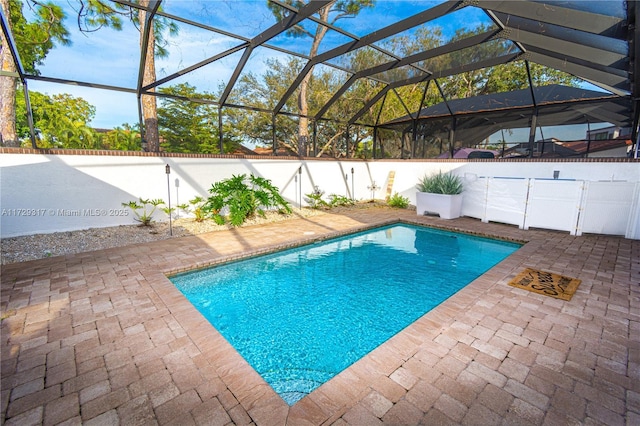 view of swimming pool featuring a lanai and a patio area