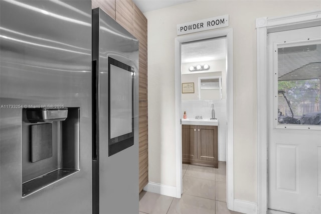 kitchen with stainless steel fridge with ice dispenser and light tile patterned floors