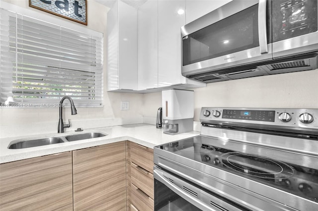 kitchen featuring white cabinetry, appliances with stainless steel finishes, and sink