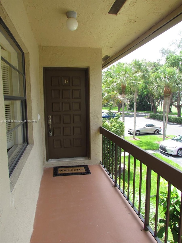 view of exterior entry with a balcony