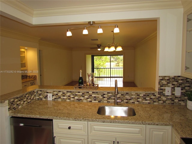 kitchen featuring pendant lighting, dishwasher, sink, decorative backsplash, and ornamental molding