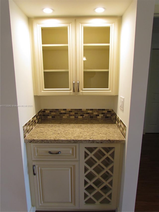 bar with stone countertops and backsplash