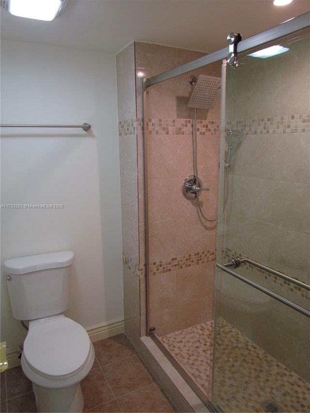 bathroom featuring walk in shower, toilet, and tile patterned flooring