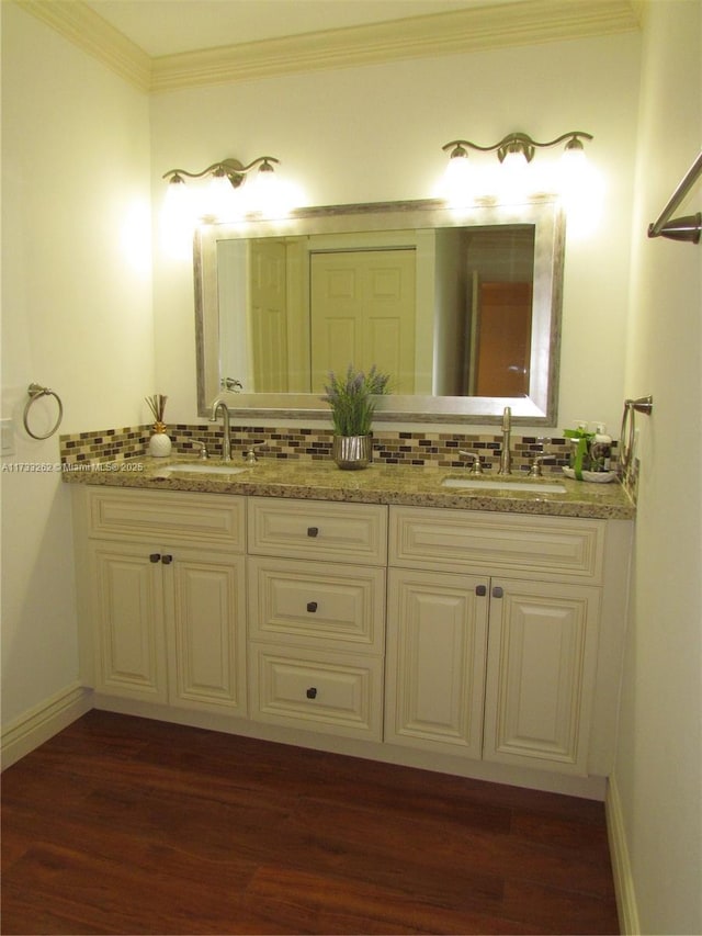 bathroom with vanity, wood-type flooring, backsplash, and ornamental molding