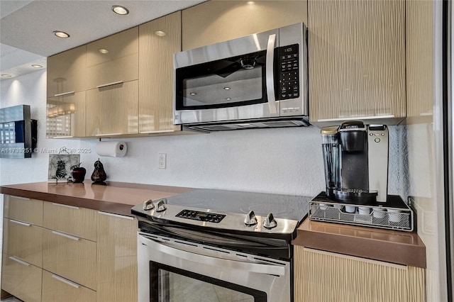 kitchen with light brown cabinetry and appliances with stainless steel finishes