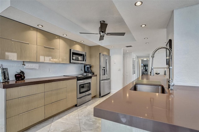 kitchen featuring sink, stainless steel appliances, ceiling fan, and light brown cabinets