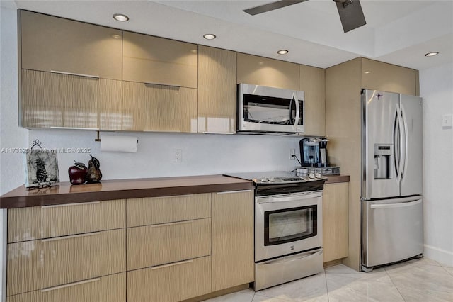 kitchen featuring wood counters, light tile patterned floors, and appliances with stainless steel finishes