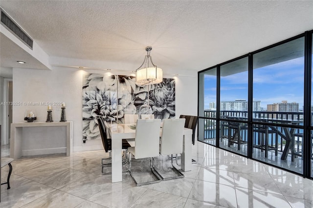 dining area with a wall of windows and a textured ceiling