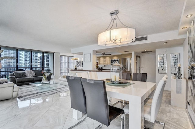 dining area with floor to ceiling windows and a textured ceiling