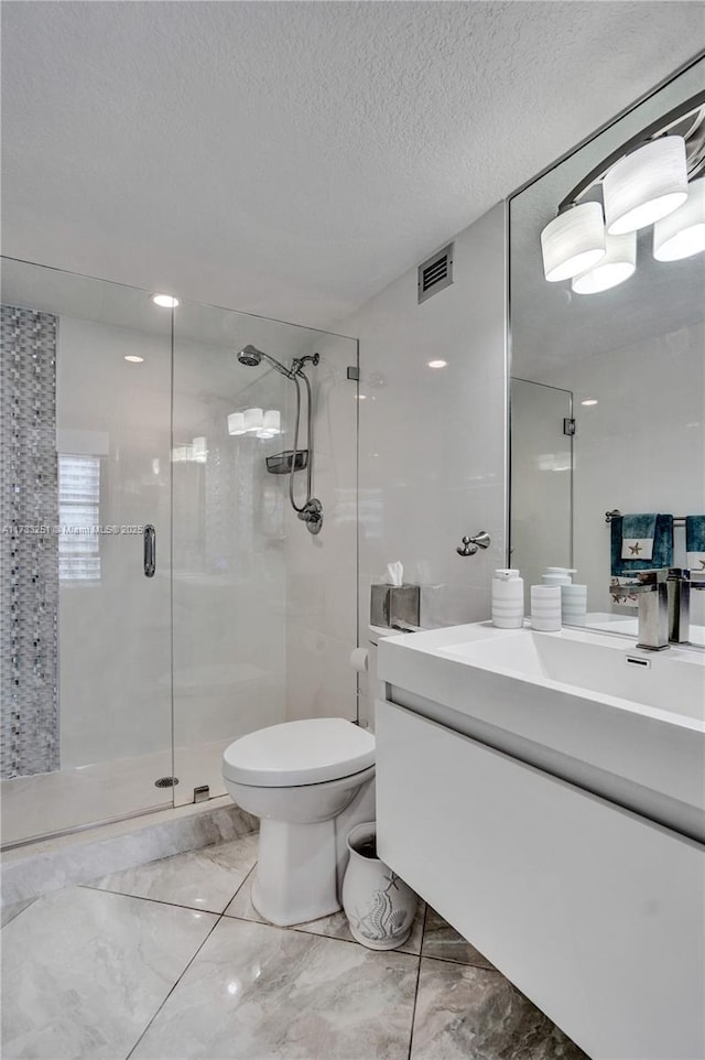 bathroom featuring an enclosed shower, vanity, toilet, and a textured ceiling