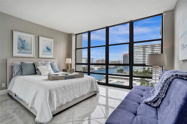 bedroom featuring a water view and expansive windows