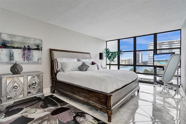 bedroom with floor to ceiling windows and a textured ceiling