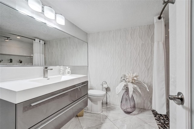 bathroom with vanity, a textured ceiling, and toilet