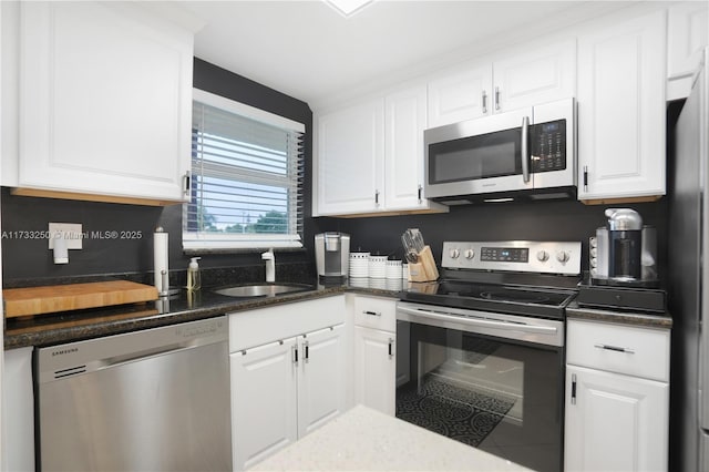 kitchen featuring white cabinetry, tile patterned floors, stainless steel appliances, and sink