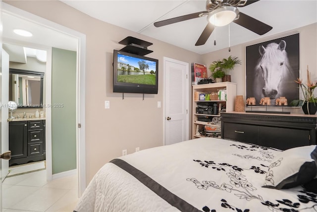 bedroom with light tile patterned floors, ensuite bath, and ceiling fan