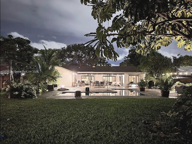 back of house featuring a patio and a lawn