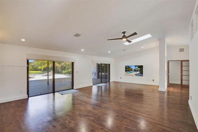 unfurnished living room featuring ceiling fan, dark hardwood / wood-style floors, and vaulted ceiling with skylight