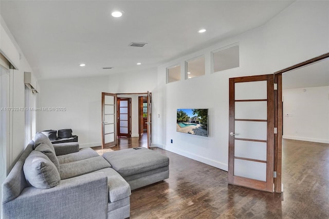 living room featuring dark hardwood / wood-style flooring, high vaulted ceiling, and french doors