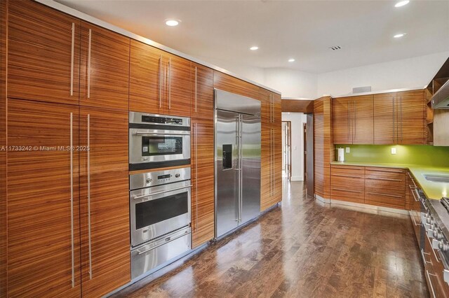 kitchen with appliances with stainless steel finishes, sink, and dark hardwood / wood-style flooring