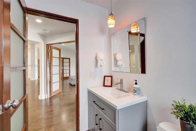 bathroom featuring hardwood / wood-style flooring, vanity, and toilet