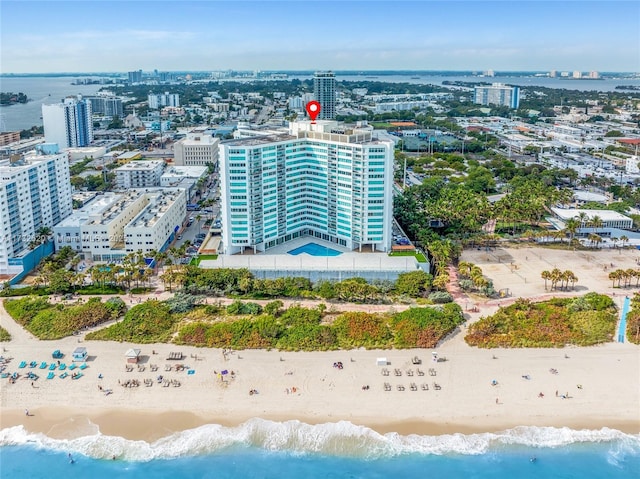 birds eye view of property featuring a water view and a beach view