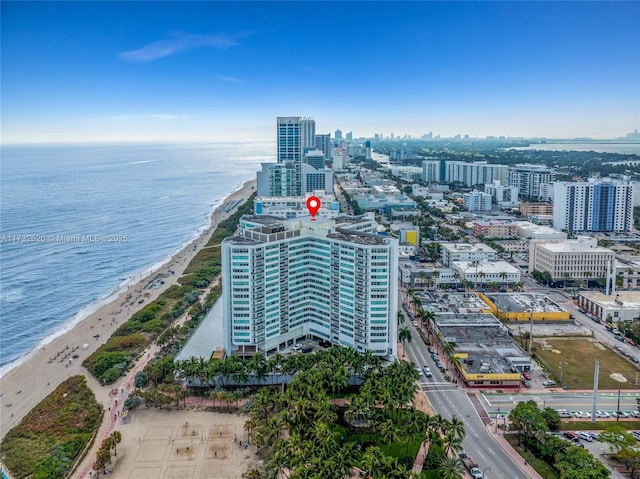 birds eye view of property with a water view and a beach view