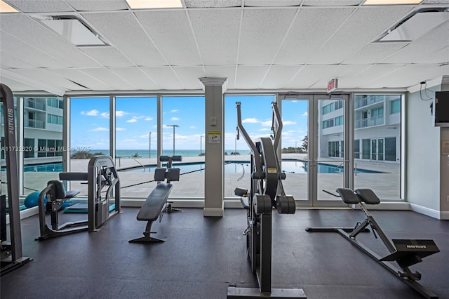 gym featuring floor to ceiling windows and a drop ceiling