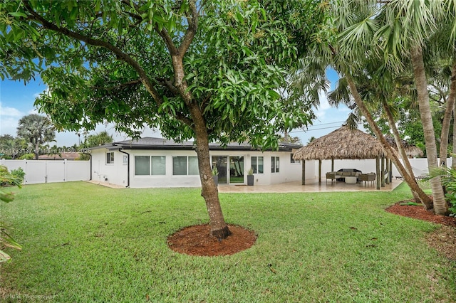 rear view of property featuring a yard, a gazebo, a patio area, and an outdoor hangout area