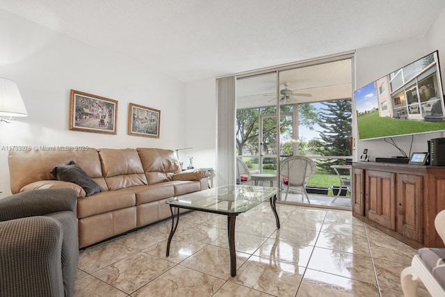 living room with expansive windows and ceiling fan