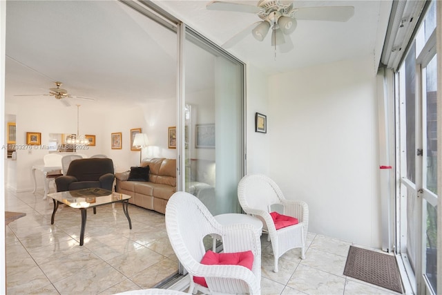 sunroom / solarium featuring ceiling fan with notable chandelier