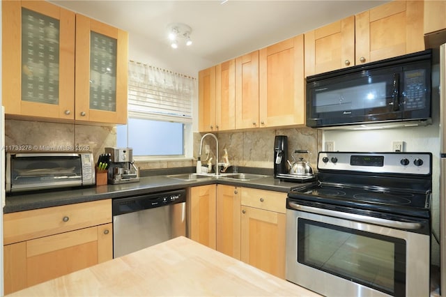 kitchen featuring light brown cabinetry, sink, backsplash, and stainless steel appliances