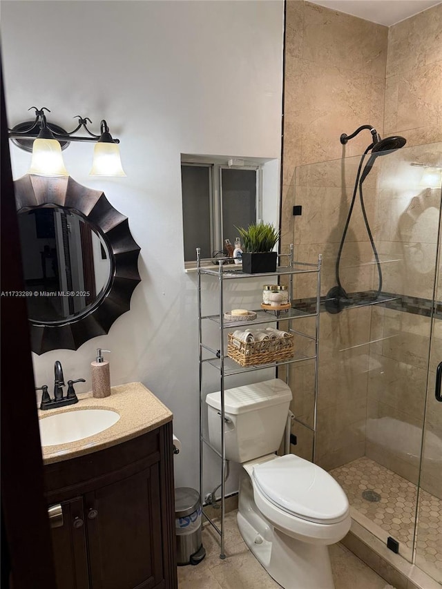 bathroom featuring vanity, toilet, an enclosed shower, and tile patterned flooring