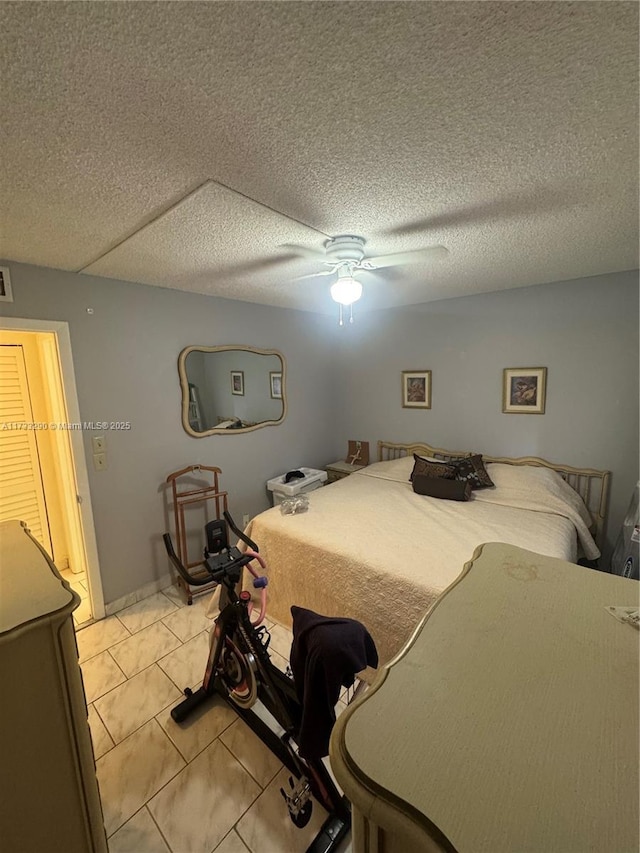 tiled bedroom featuring a textured ceiling and ceiling fan