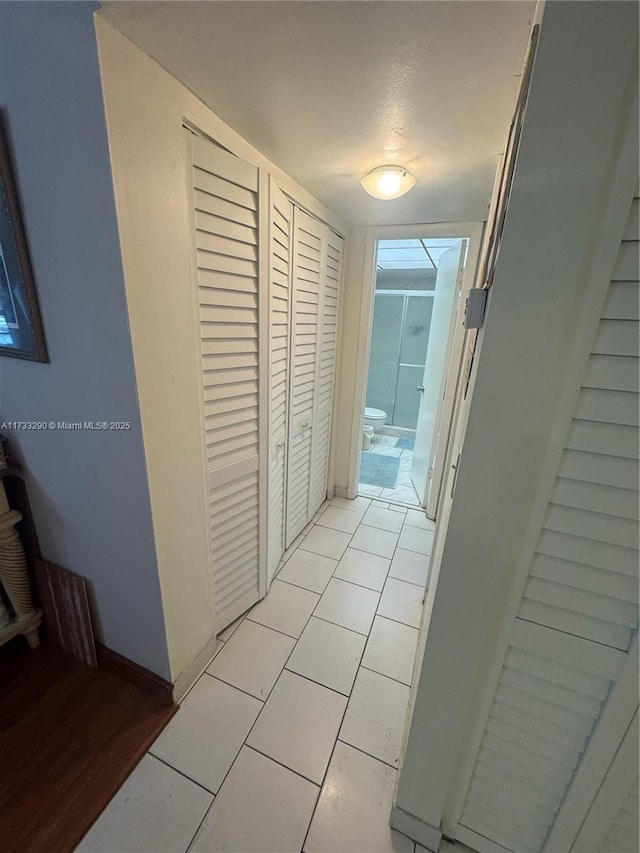 hall featuring light tile patterned floors