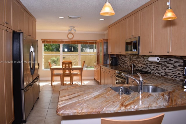 kitchen featuring sink, light tile patterned floors, backsplash, stainless steel appliances, and kitchen peninsula