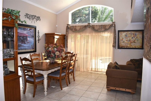 tiled dining area with lofted ceiling and ornamental molding