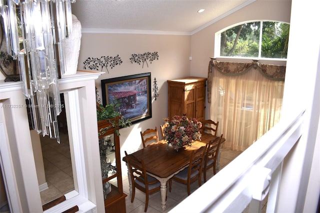 dining area with tile patterned flooring, ornamental molding, and a textured ceiling