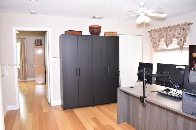 office area featuring a healthy amount of sunlight, a textured ceiling, and light hardwood / wood-style flooring