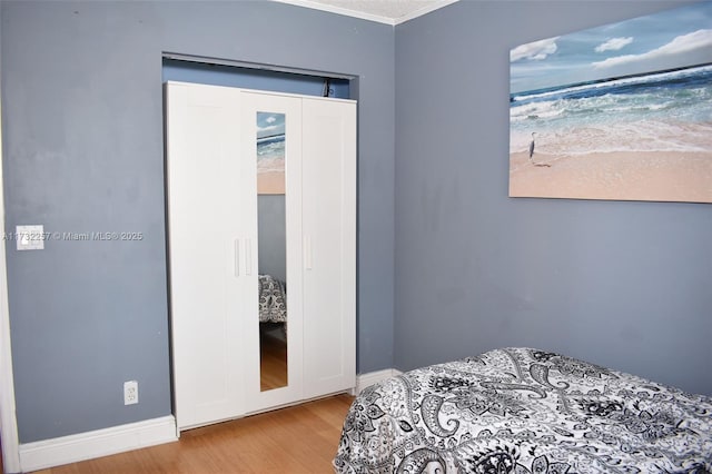 bedroom featuring crown molding and light wood-type flooring