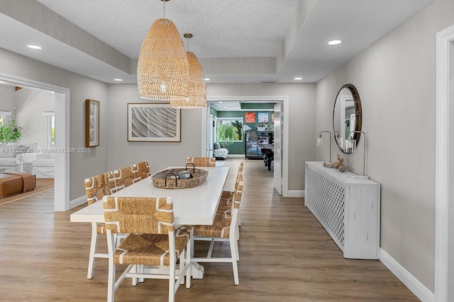 dining space with wood finished floors, baseboards, recessed lighting, and a chandelier