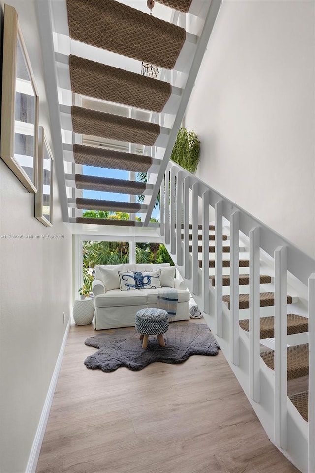 staircase with wood finished floors and baseboards