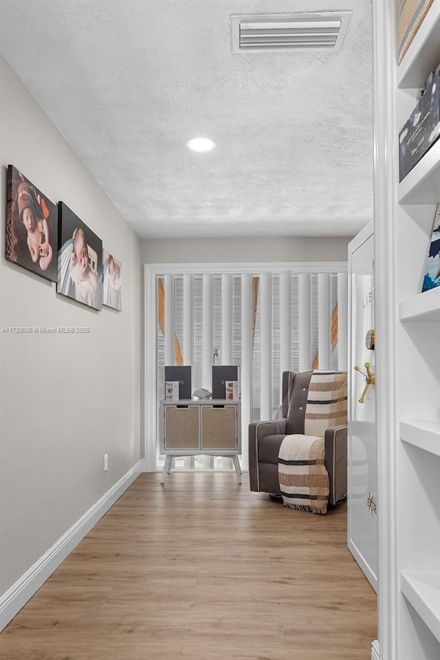 sitting room featuring baseboards, wood finished floors, visible vents, and recessed lighting