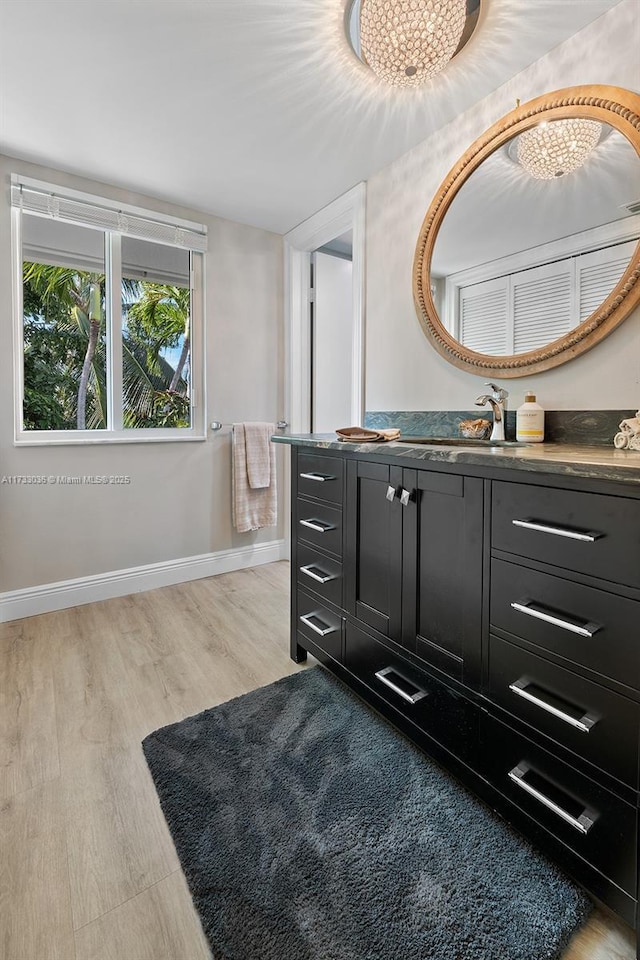 bathroom featuring baseboards, vanity, and wood finished floors