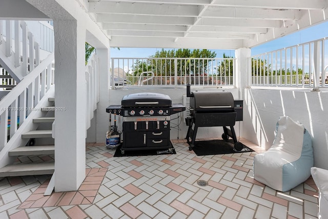 view of patio / terrace featuring grilling area, stairway, and fence