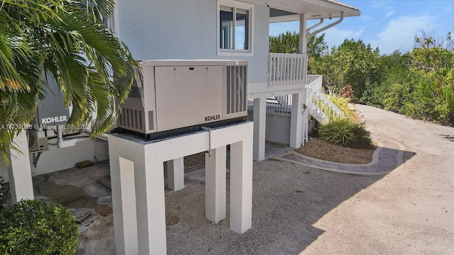 details with stucco siding, stairway, and a power unit