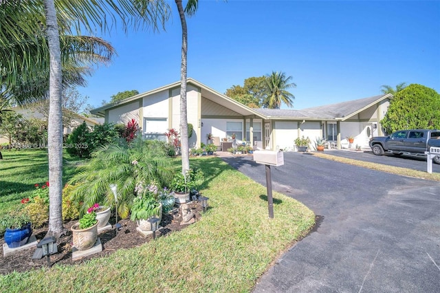 ranch-style home featuring a garage and a front lawn