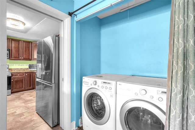 laundry room featuring independent washer and dryer and light hardwood / wood-style floors